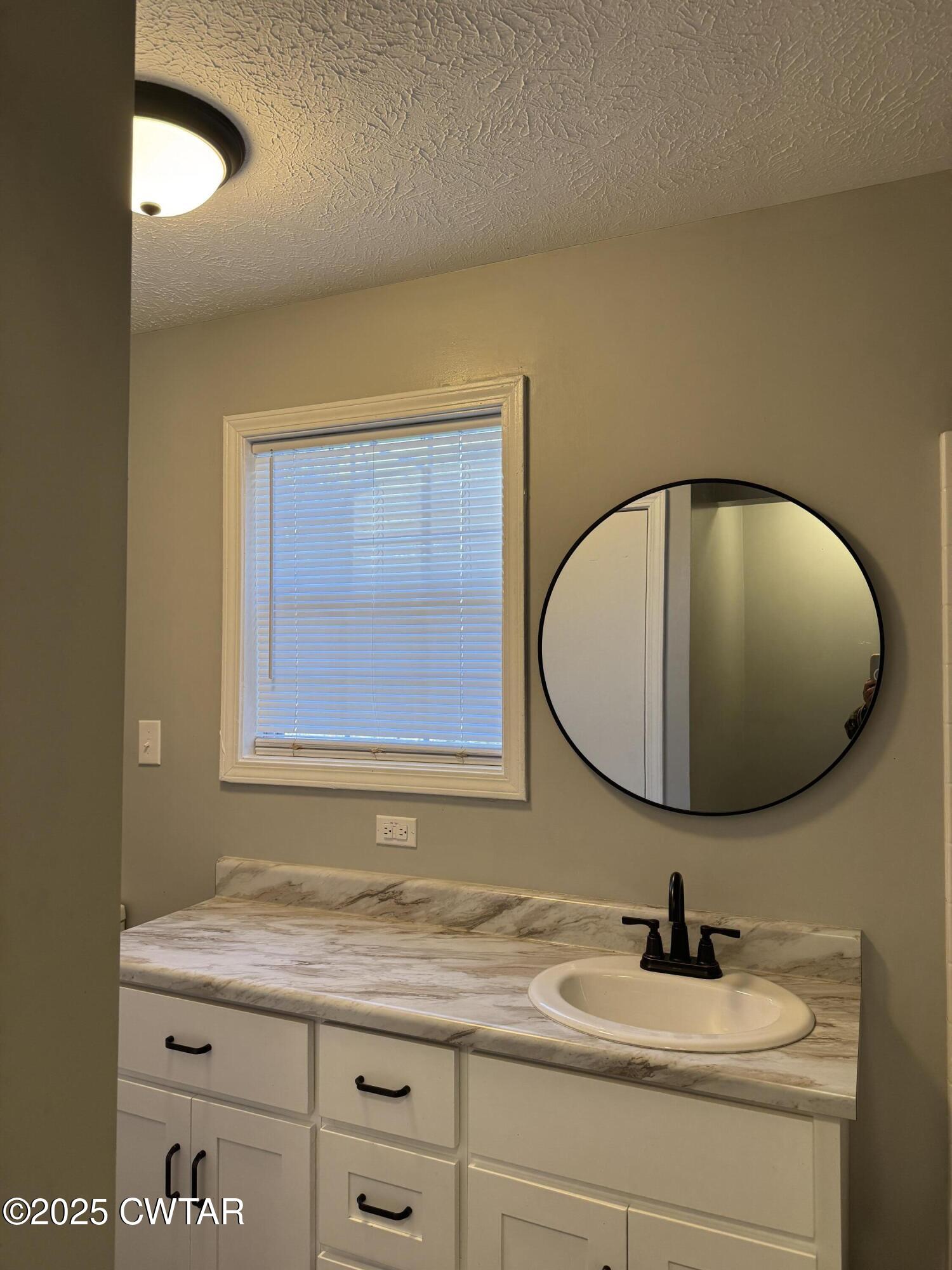380 Patterson Lane Finger, TN 38334 - Photo 21 of 25 a bathroom with a granite countertop sink and a mirror