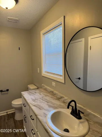 a bathroom with a sink a toilet and a mirror