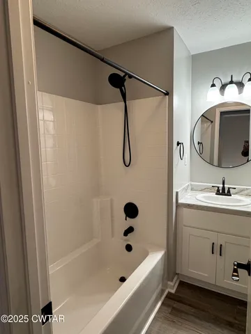 a bathroom with a tub sink a vanity and a mirror
