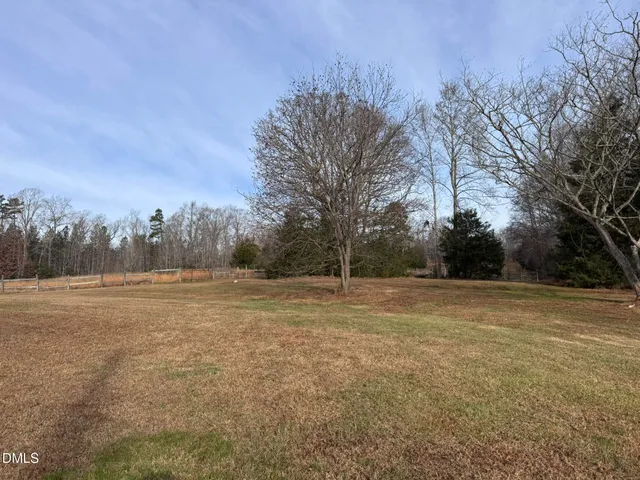 a view of a field with trees in the background