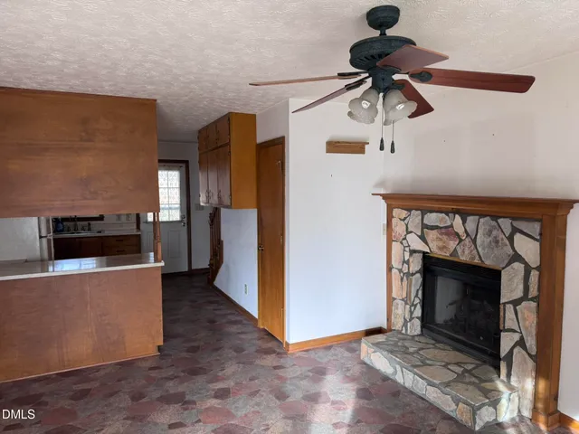 a view of a livingroom with a fireplace and kitchen