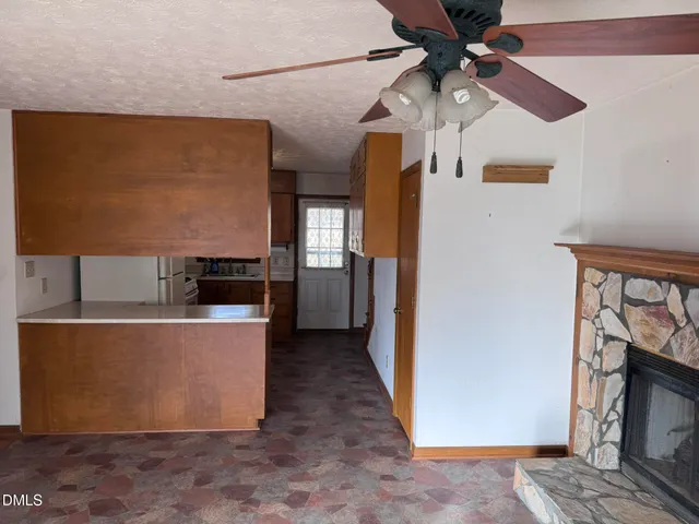 a view of a kitchen with fridge and wooden floor