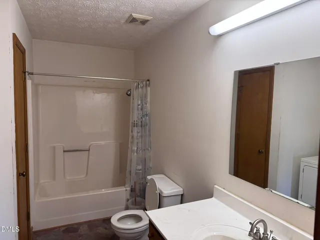 a bathroom with a shower a toilet and sink