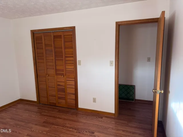 an empty room with wooden floor and closet