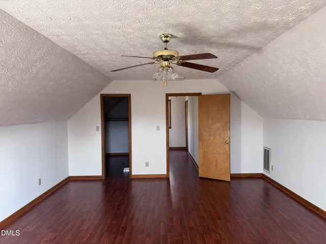 a view of a livingroom with wooden floor and a ceiling fan