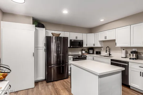 a kitchen with a refrigerator a stove top oven a sink and cabinets