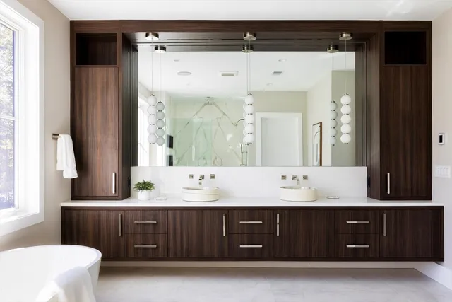 a bathroom with a double vanity sink mirror and bathtub