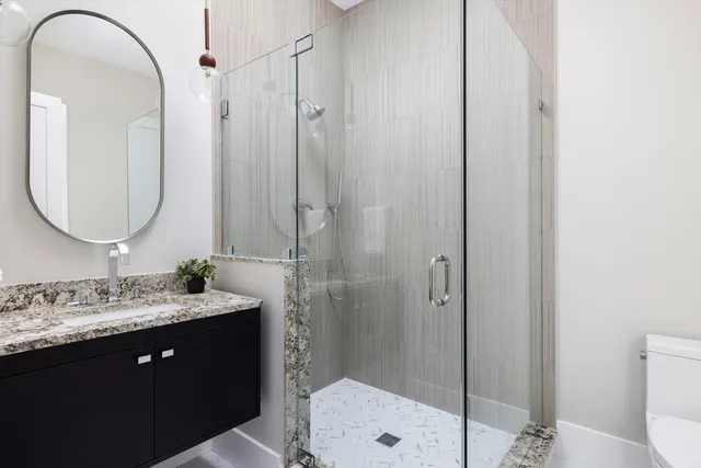 a bathroom with a double vanity sink mirror and shower