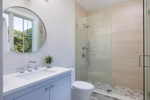 a bathroom with a sink toilet a mirror and shower