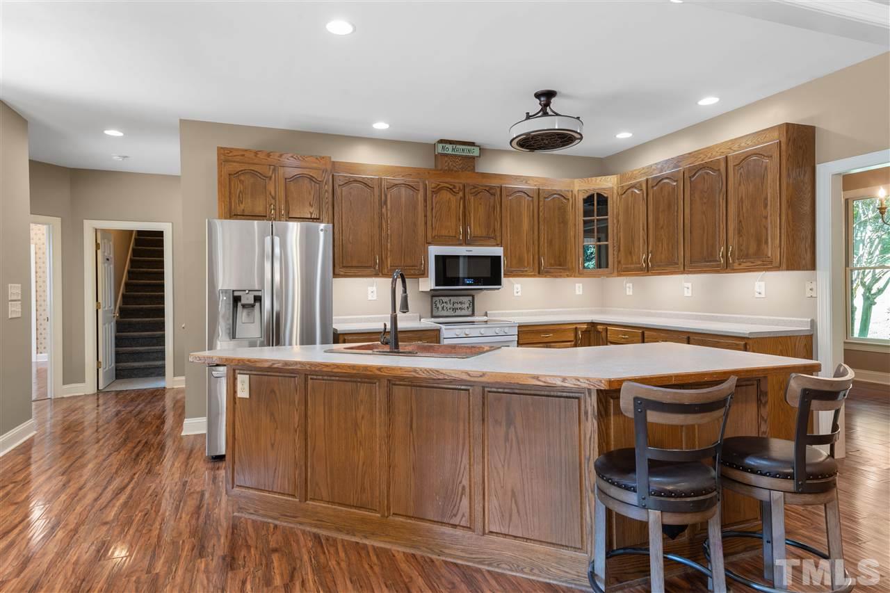 12804 Summerwind Trail Rougemont, NC 27572 - Photo 13 of 27 a kitchen with granite countertop a table chairs microwave and cabinets