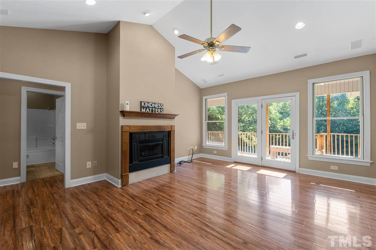 12804 Summerwind Trail Rougemont, NC 27572 - Photo 14 of 27 a view of an empty room with wooden floor fireplace and a window