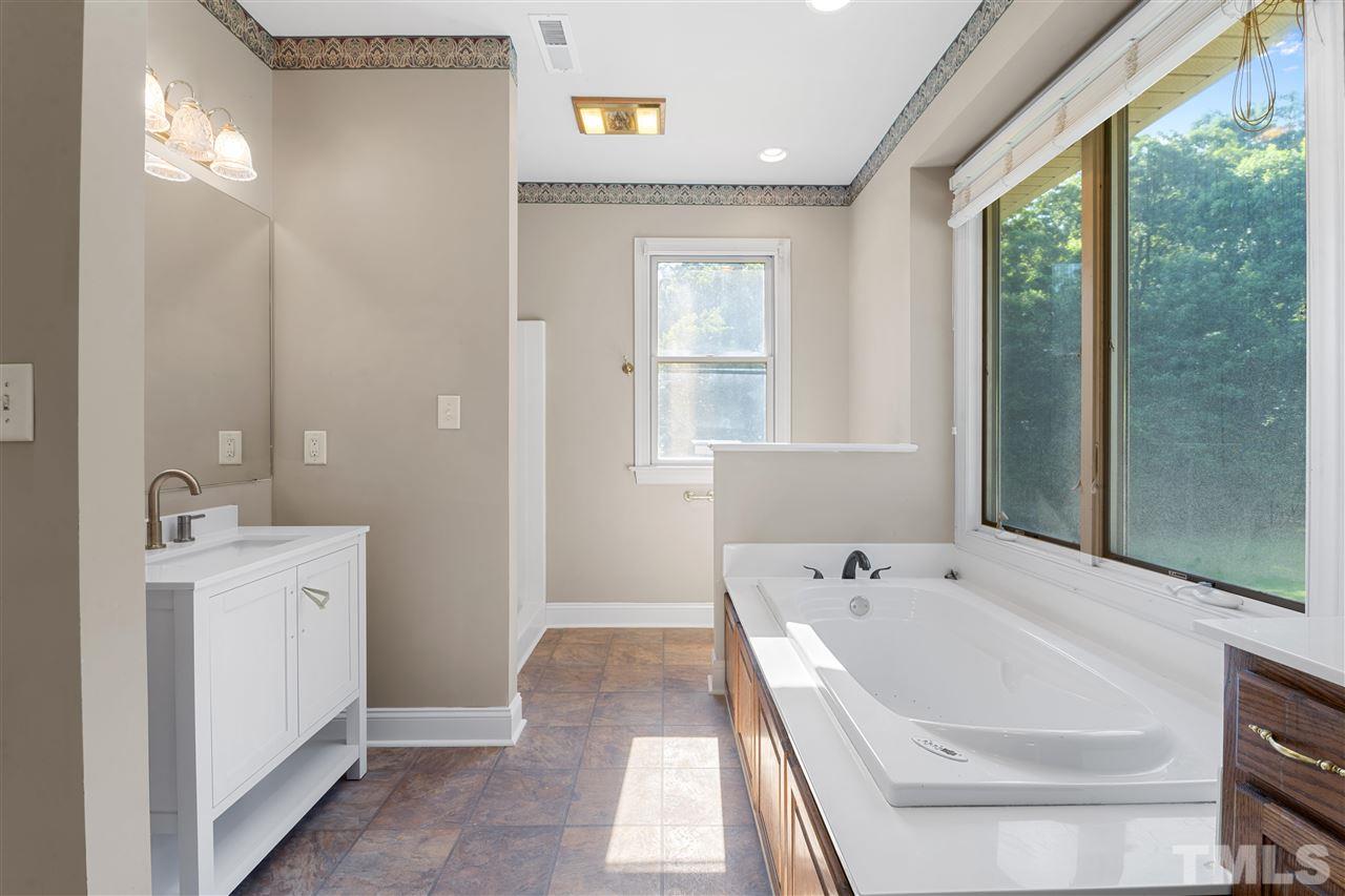 12804 Summerwind Trail Rougemont, NC 27572 - Photo 21 of 27 a bathroom with a tub a sink and a large mirror