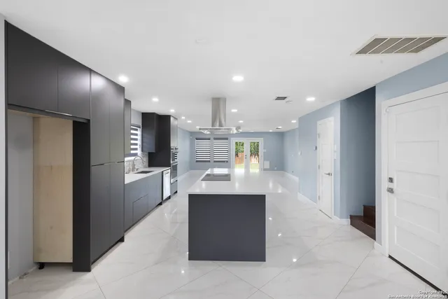a large kitchen with a large counter top stainless steel appliances and cabinets
