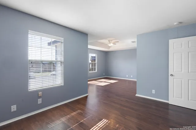a view of empty room with wooden floor and window
