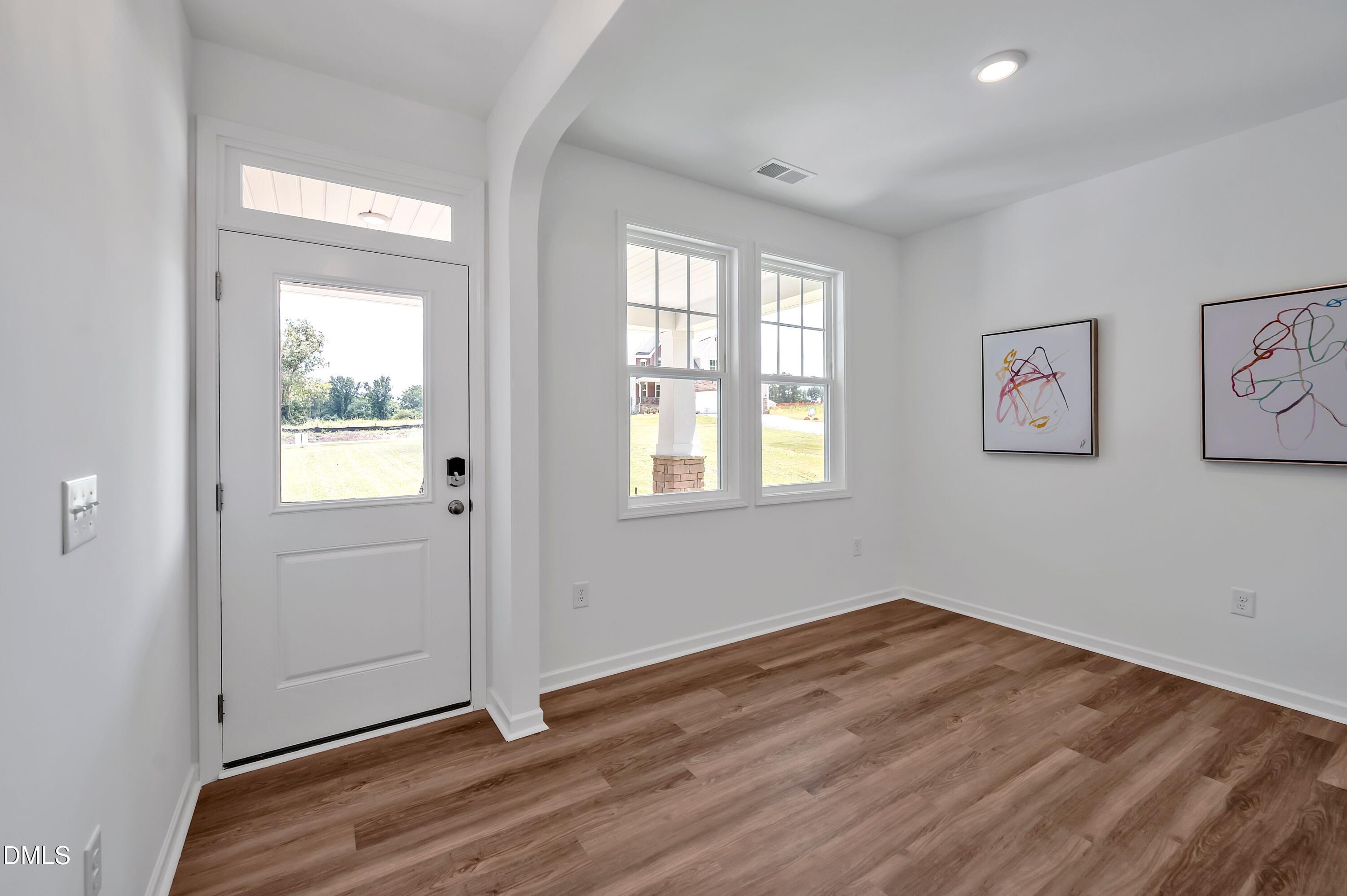 236 White Azalea Way Benson, NC 27504 - Photo 12 of 18 an empty room with wooden floor and windows