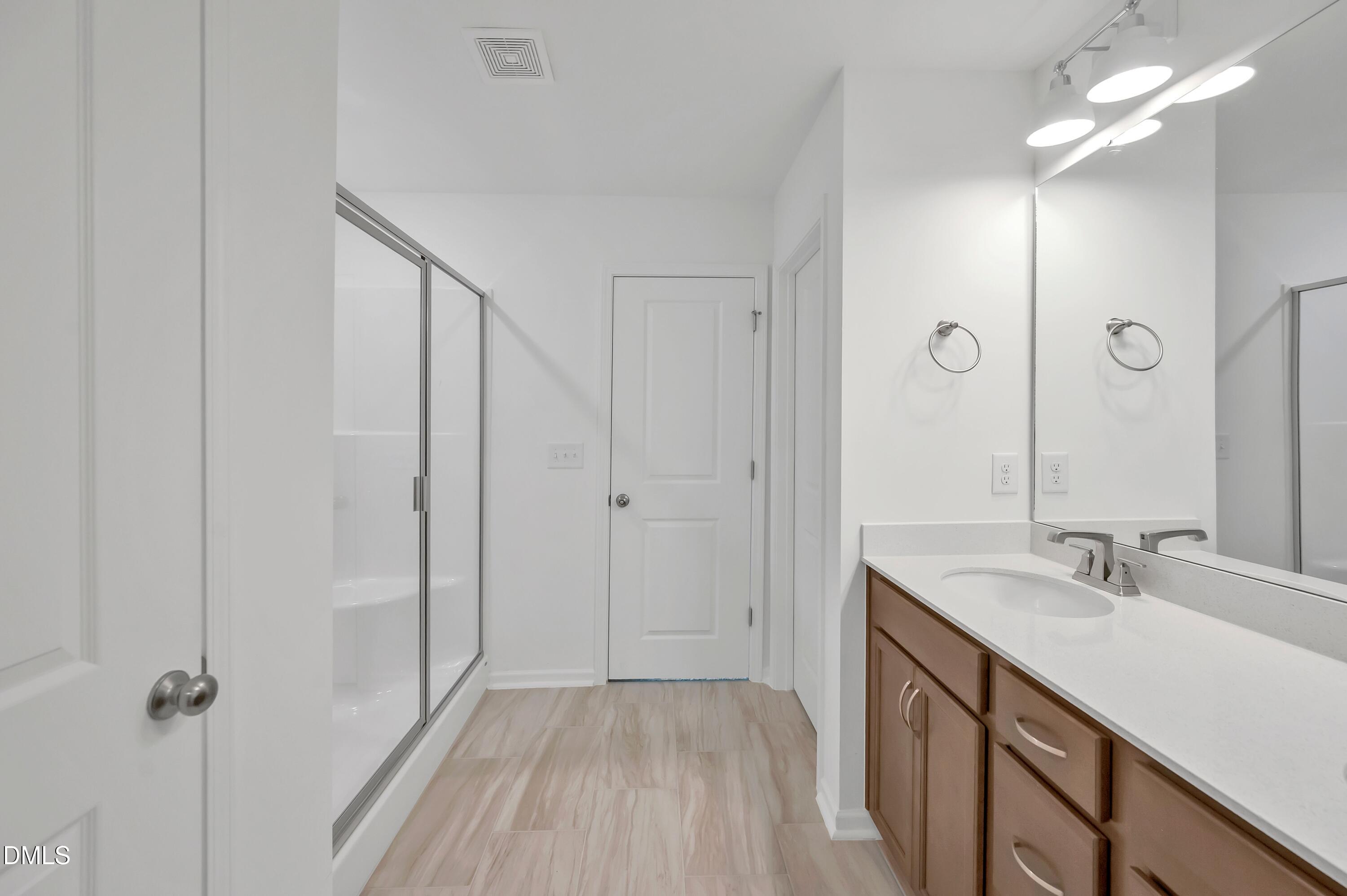236 White Azalea Way Benson, NC 27504 - Photo 14 of 18 a bathroom with a sink a mirror and a shower