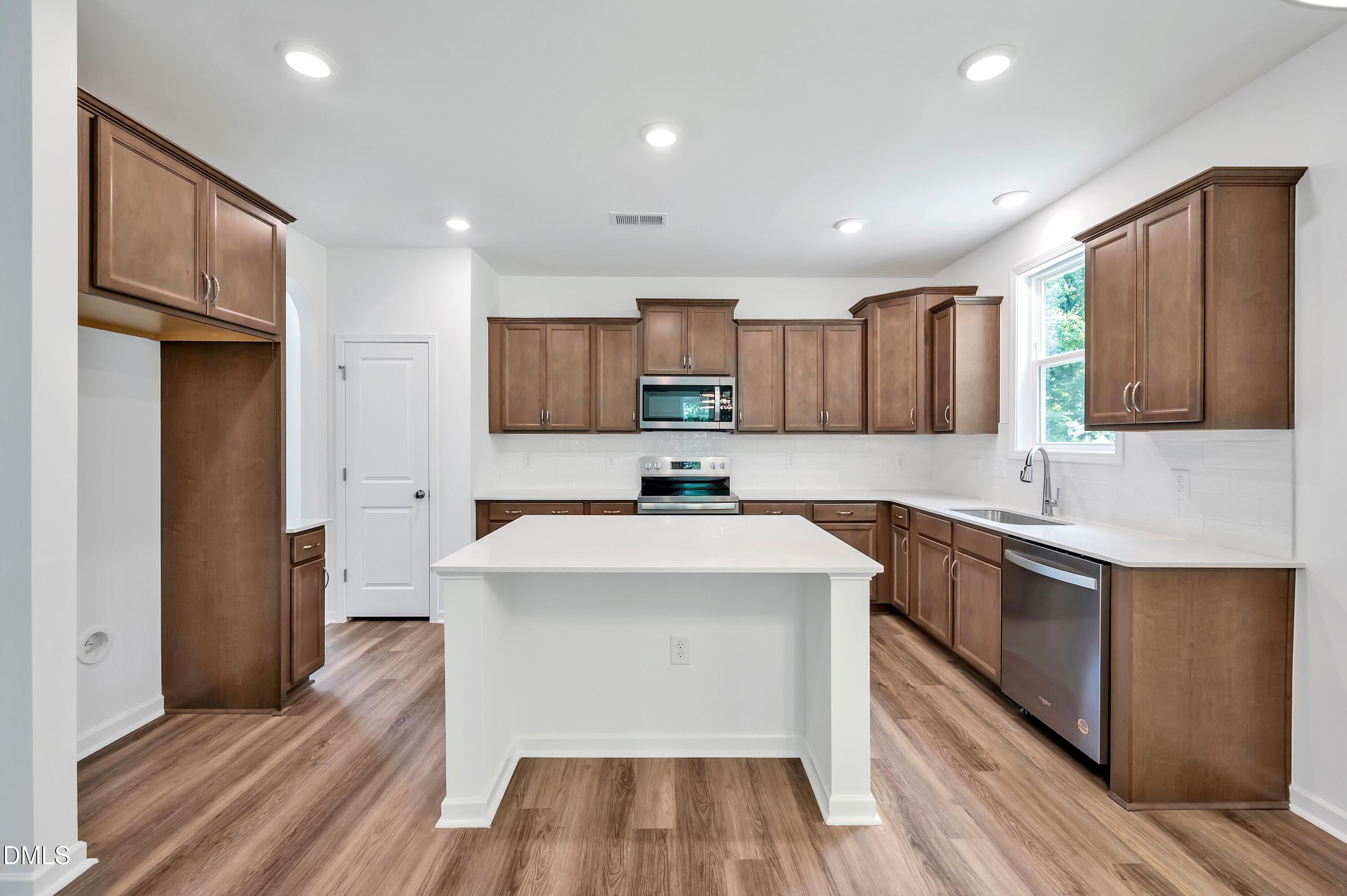 236 White Azalea Way Benson, NC 27504 - Photo 7 of 18 a kitchen with stainless steel appliances a sink stove and refrigerator
