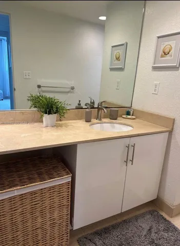 a bathroom with a granite countertop sink and a mirror