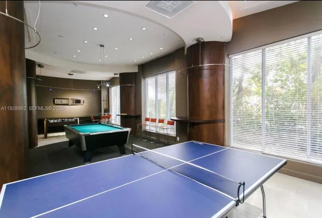 a room with pool table and windows