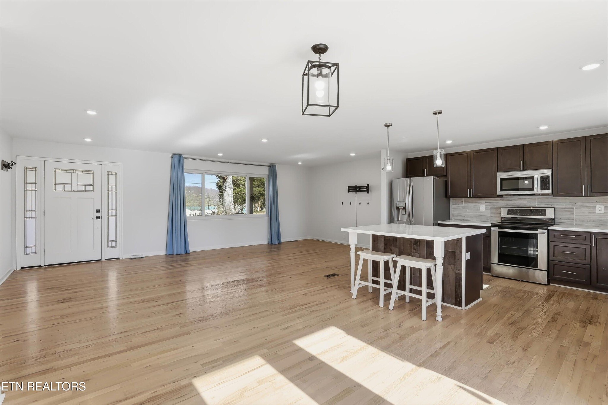 6120 Cline Road Knoxville, TN 37938 - Photo 7 of 29 a kitchen with stainless steel appliances granite countertop a stove top oven a sink a dining table and chairs with wooden floor