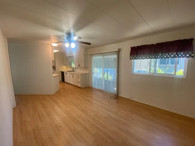 an empty room with a kitchen and a window