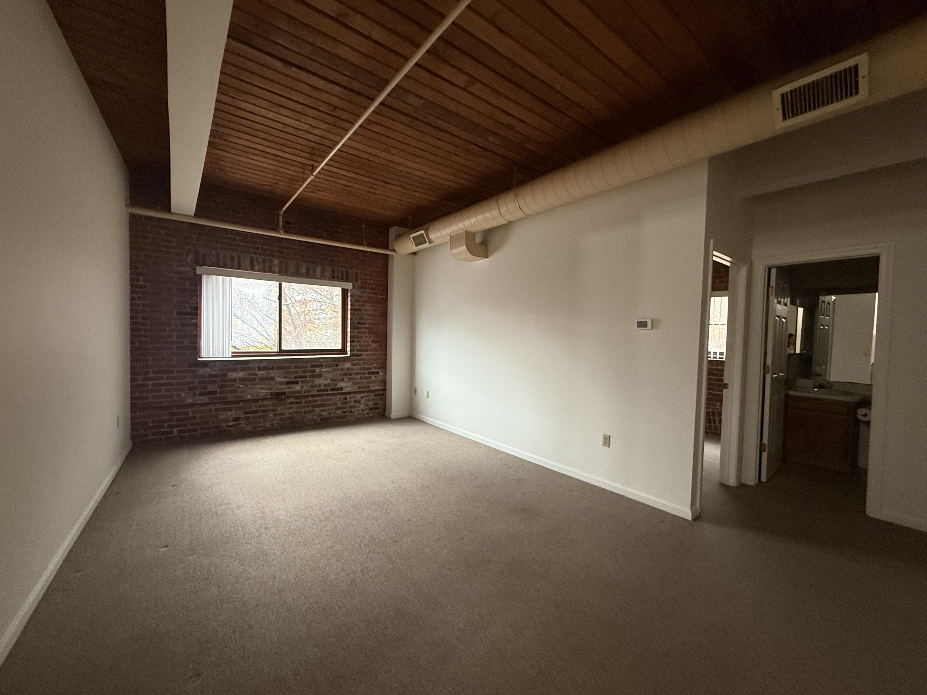 a view of empty room with wooden floor and windows
