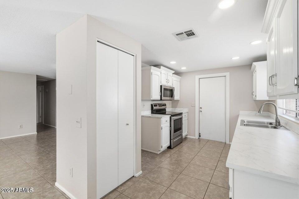 1525 West El Alba Way Chandler, AZ 85224 - Photo 14 of 33 a kitchen with white cabinets and white appliances