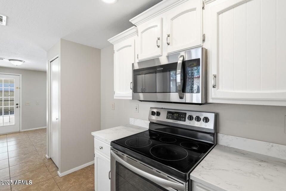1525 West El Alba Way Chandler, AZ 85224 - Photo 17 of 33 a kitchen with stainless steel appliances a stove and a microwave