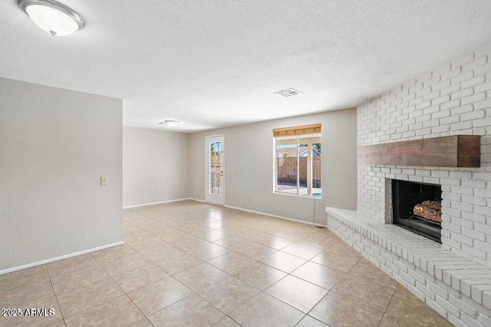 1525 West El Alba Way Chandler, AZ 85224 - Photo 7 of 33 a view of an empty room with a fireplace and a window