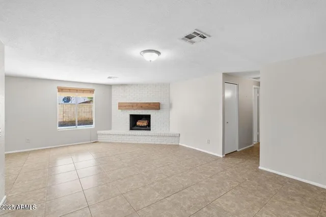 a view of empty room with a fireplace