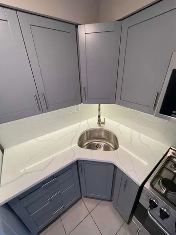 a kitchen with granite countertop a stove and a sink
