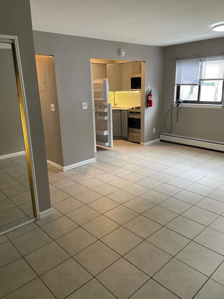 17 68th Street, Unit 7 Guttenberg, NJ 07093 - Photo 5 of 30 an empty room with fireplace and windows