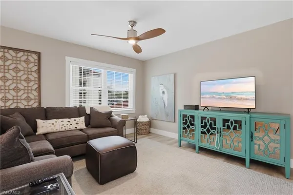 a living room with furniture a ceiling fan and a window