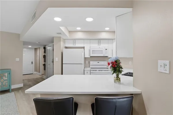 a kitchen with refrigerator and white cabinets