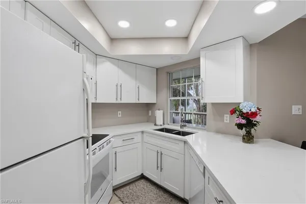 a kitchen that has a lot of cabinets a sink and appliances in it