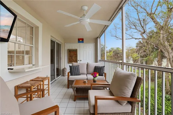 a living room with furniture and floor to ceiling windows