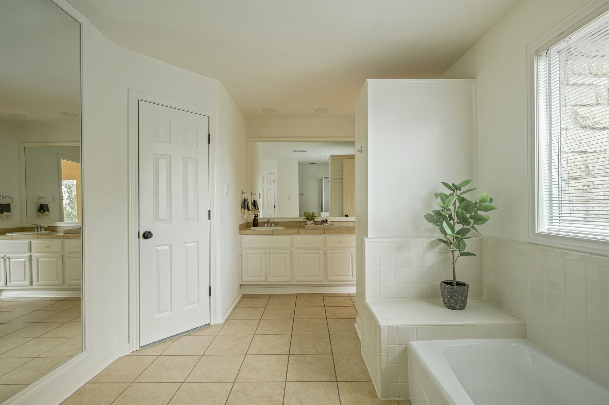6010 Long Champ Court, Unit 113 Austin, TX 78746 - Photo 22 of 25 Bathroom with light tile patterned floors, a bath, and vanity