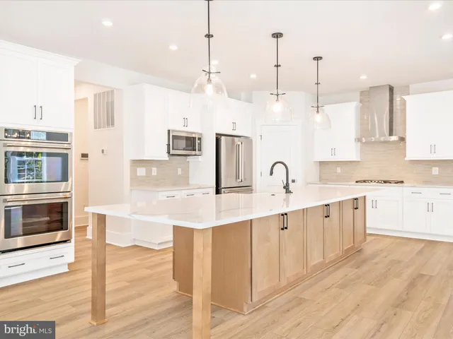 a large kitchen with cabinets a sink and stainless steel appliances
