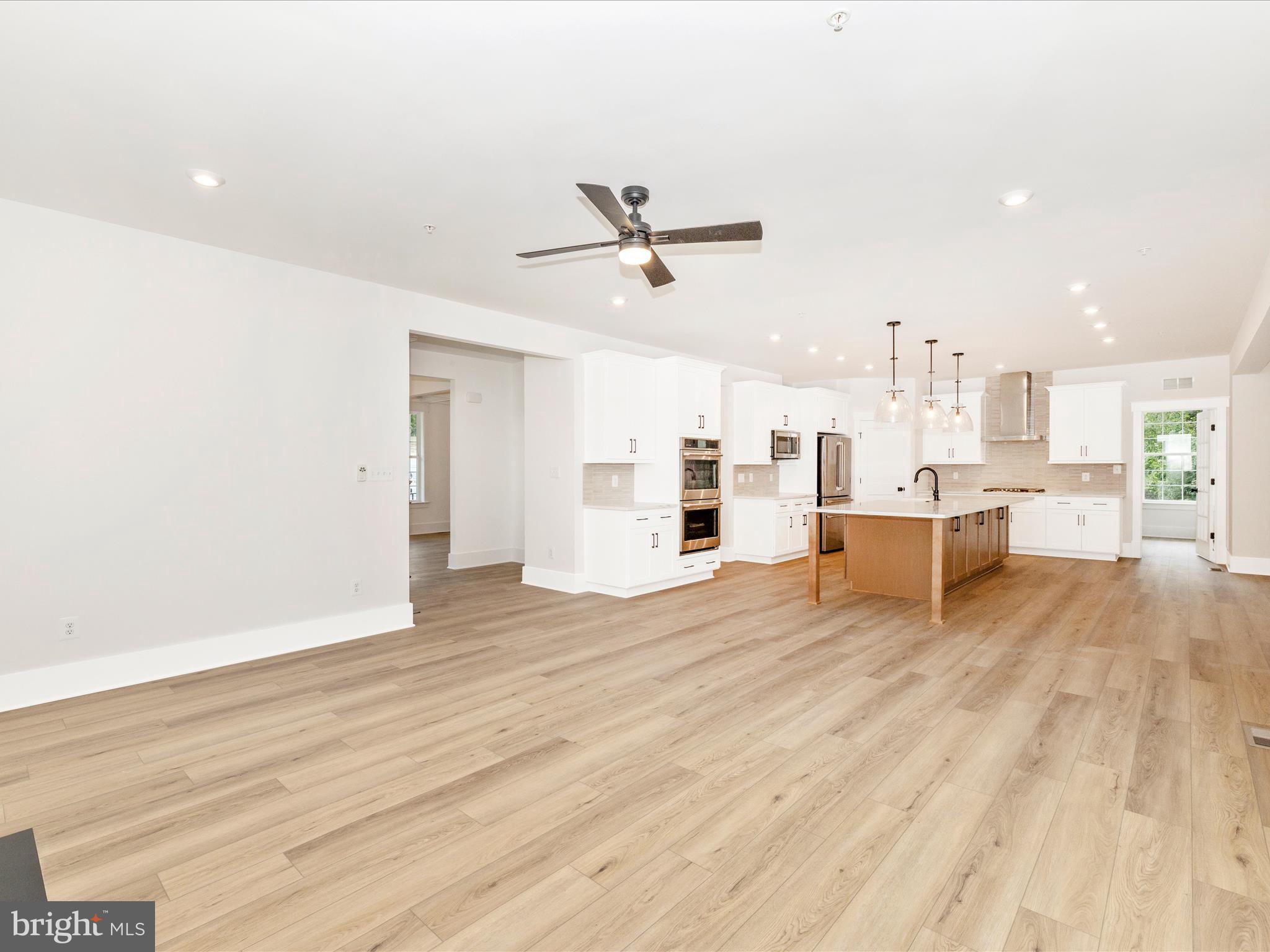 3105 Sumantown Road Middletown, MD 21769 - Photo 18 of 45 a view of a living room a kitchen island wooden floor and a ceiling fan