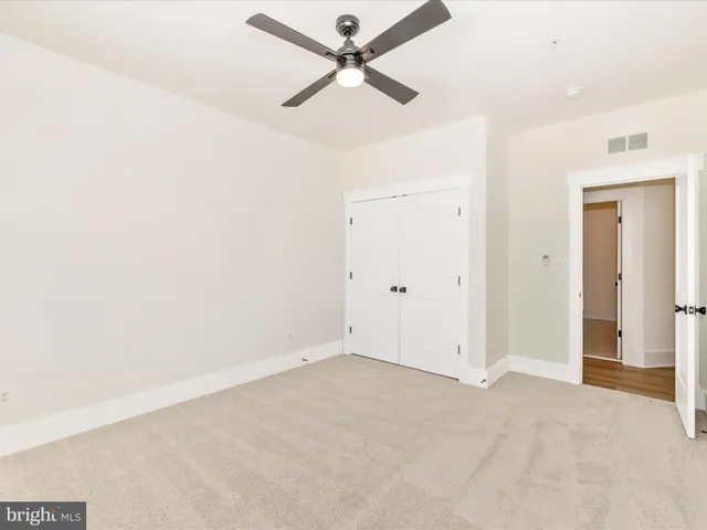 an empty room with a ceiling fan and a window