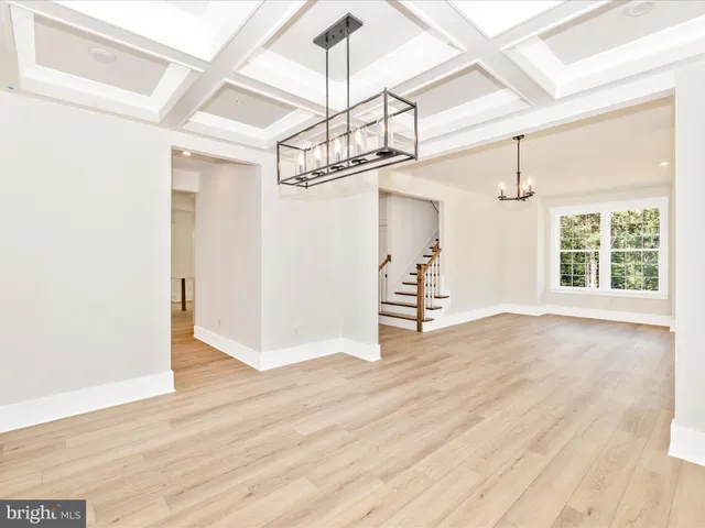 a view of an empty room with wooden floor and windows