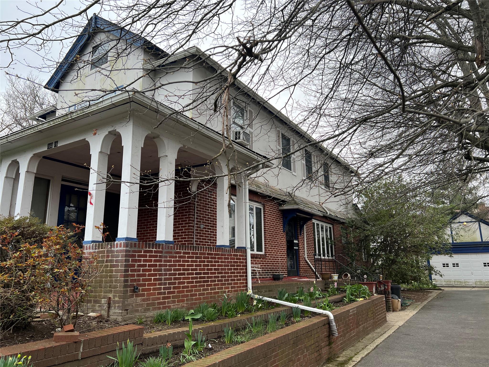 160-16 Riverside Drive Queens, NY 11357 - Photo 3 of 11 a front view of a house with garage