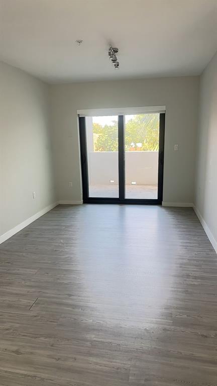 3050 Northwest 68th Street, Unit 2205 Fort Lauderdale, FL 33309 - Photo 12 of 19 a view of an empty room with wooden floor and a window