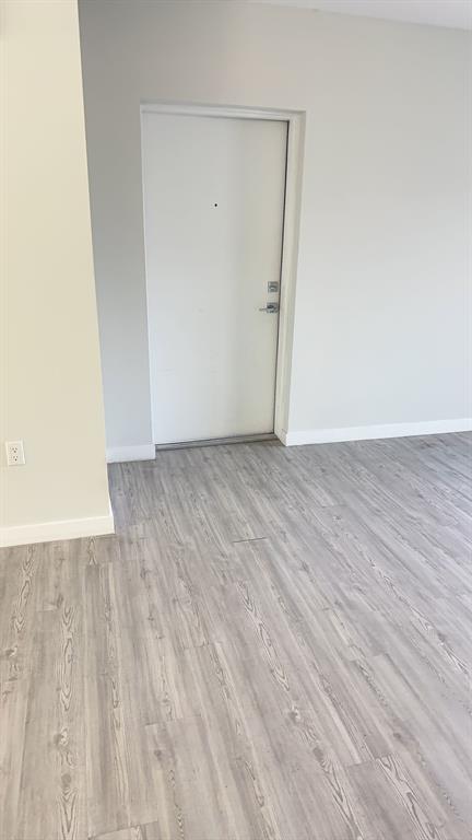 3050 Northwest 68th Street, Unit 2205 Fort Lauderdale, FL 33309 - Photo 14 of 19 a view of an empty room with wooden floor