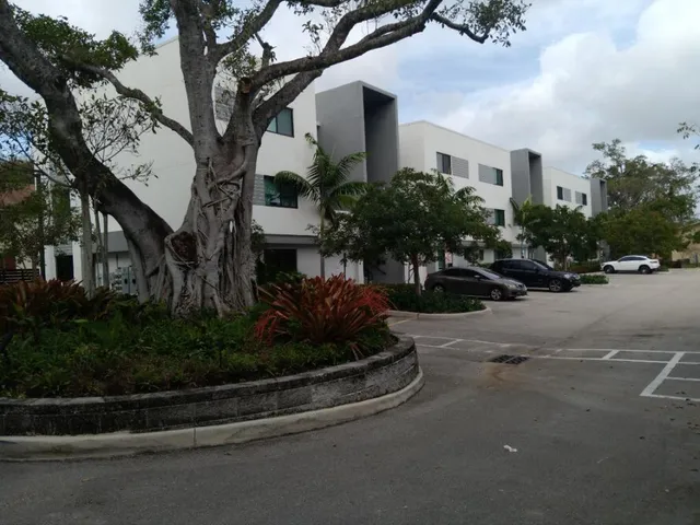 a view of a street with a building and trees in the background