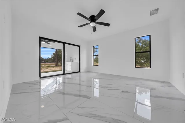 a view of an empty room with a window and a ceiling fan