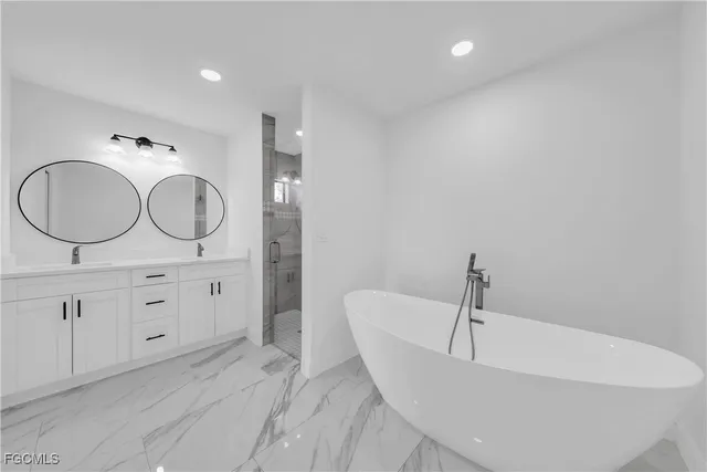a spacious bathroom with a tub sink and mirror