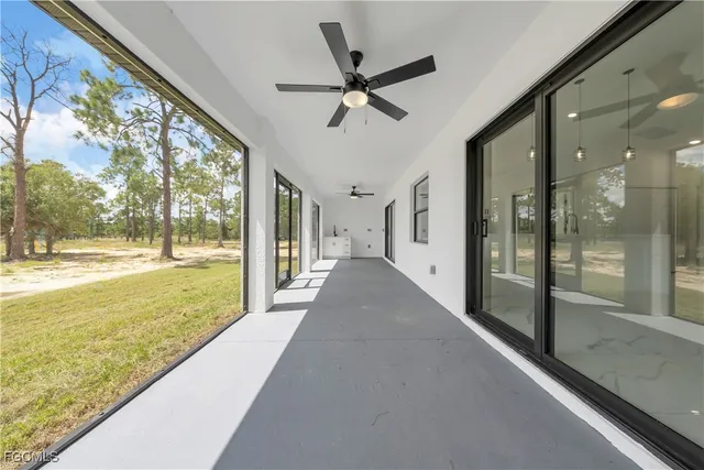 a view of a living room with a floor to ceiling window and a ceiling fan