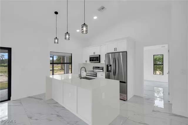 a kitchen with stainless steel appliances granite countertop a refrigerator a oven a sink a stove and a refrigerator