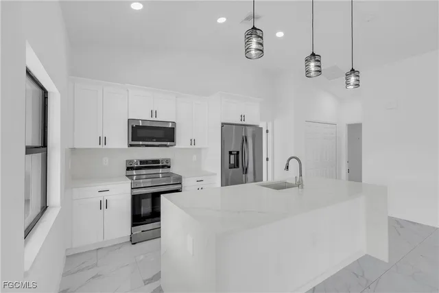 a kitchen with stainless steel appliances a stove a sink and a refrigerator